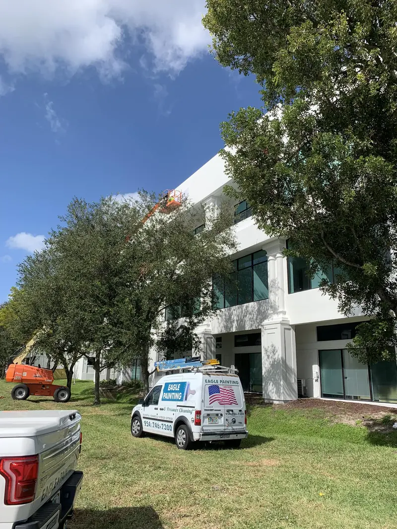 Office building repaint in Broward County with an Eagle Painting van and boom lift