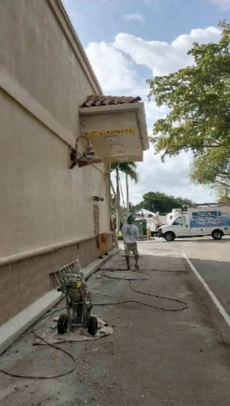 Eagle technician washing the exterior wall of a commercial building